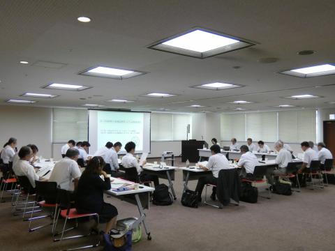 18名が着席し、協議している写真