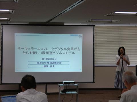 発表内容をプロジェクターでスクリーンに写し、発表している女性の写真