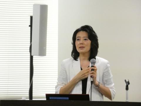発表内容をプロジェクターでスクリーンに写し、発表している女性の写真
